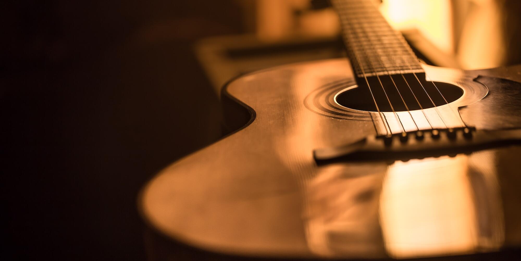 Gros plan de guitare acoustique sur un fond rose